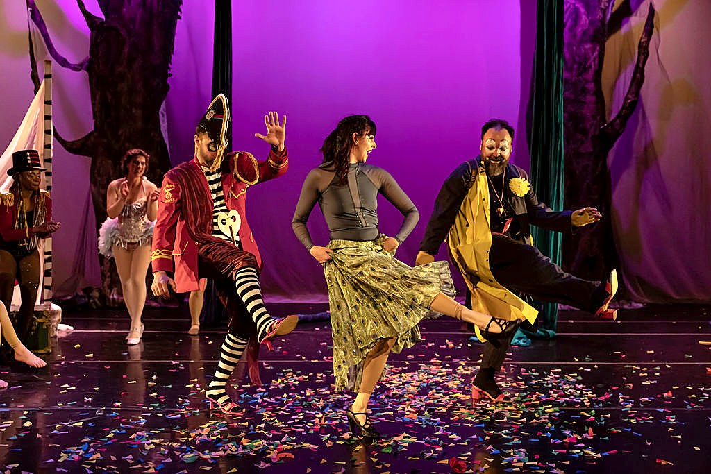 Performers dancing on stage amid falling confetti