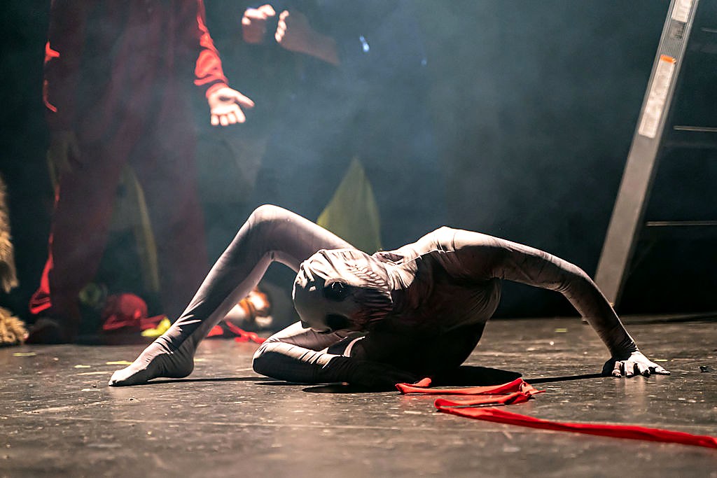 A contortionist performer under blue stage light